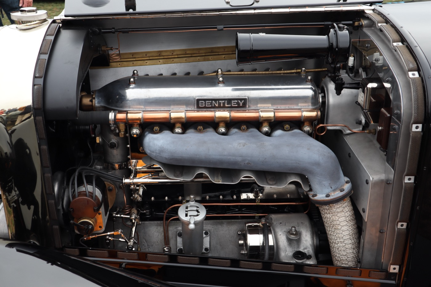 The open bonnet of a vintage Bentley showing the polished engine beneath