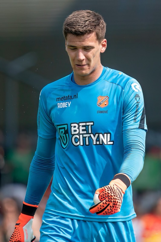 Filip Stankovic in FC Volendam's blue goalkeeper shirt, head down, during a match in May 2023